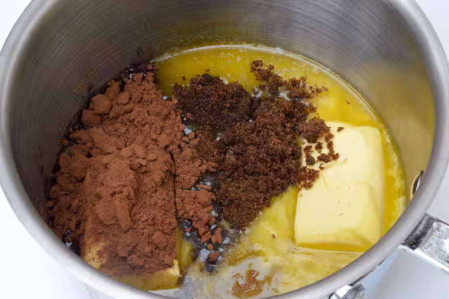Butter, cocoa and sugar melting in pan.