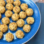Partial view of a plate of homemade apricot and coconut energy balls.