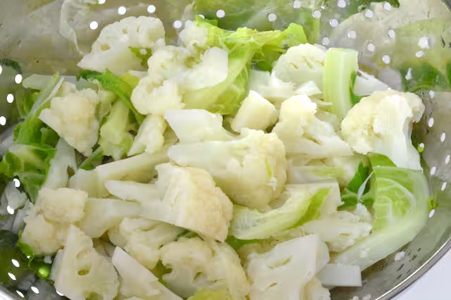 Cauli florets draining in colander.