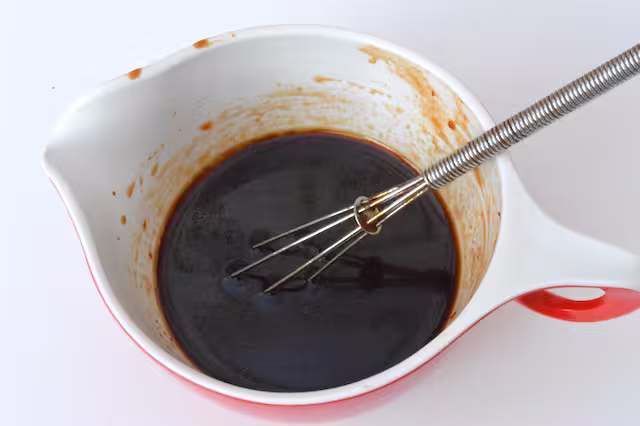 Firecracker sauce in jug with whisk.