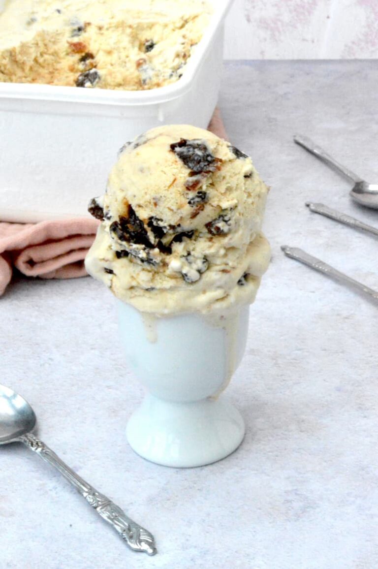 Scoops of mincemeat ice cream piled onto an eggcup with tub behind.