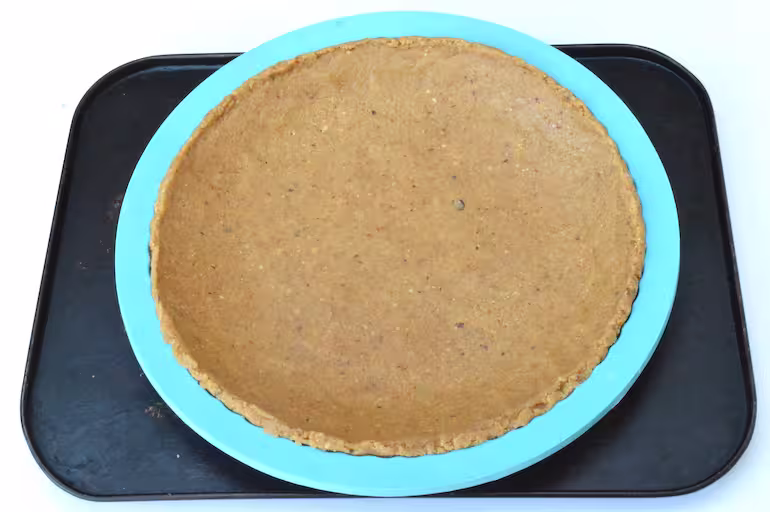 Biscuit crumb moulded into tart tin to make cheesecake base.