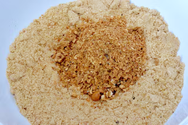 Ground biscuits and hazelnuts in bowl.