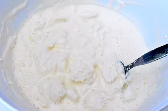 Stirring cream into cream cheese mix.
