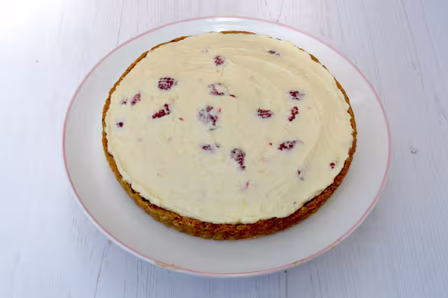 Cheesecake unmoulded and placed on cake stand.