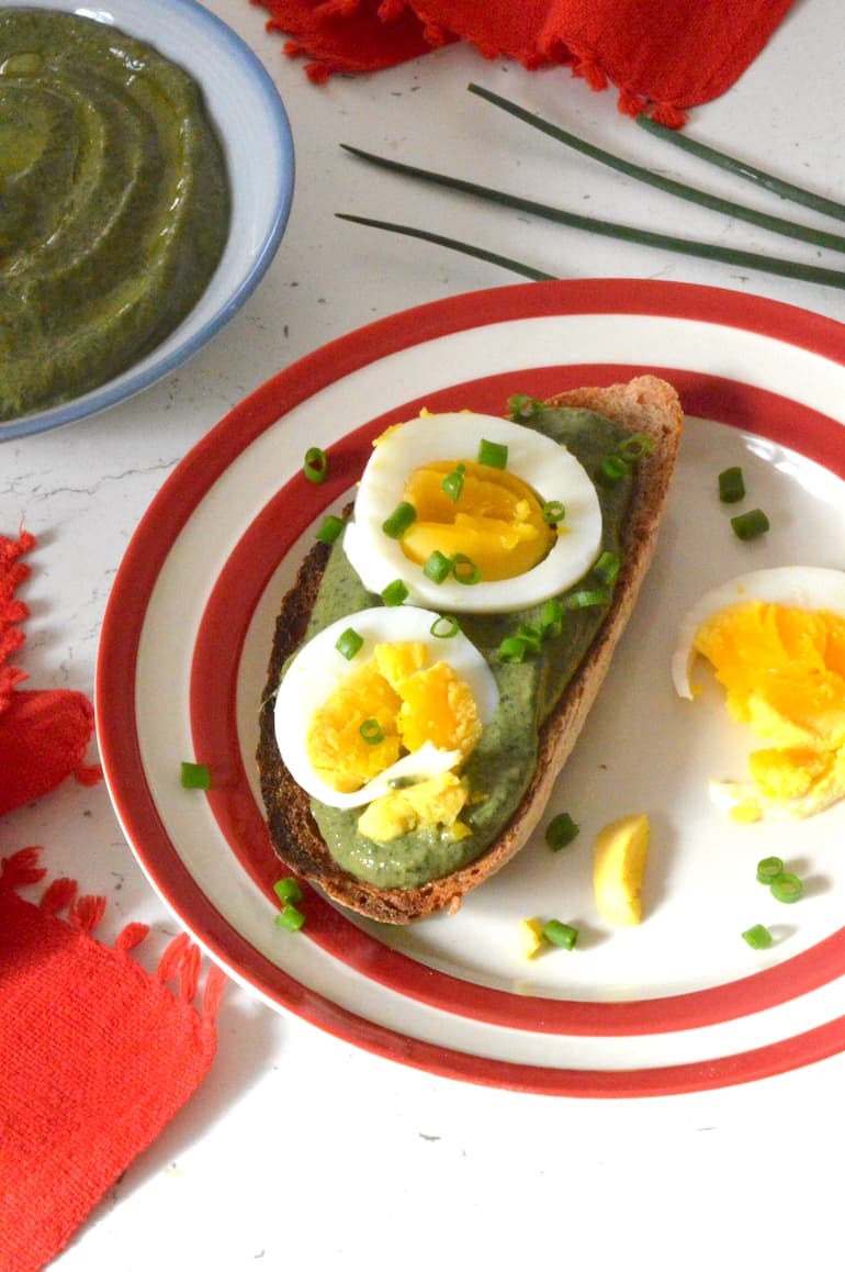 Nettle dip on slice of toast topped by egg slices and chopped chives.