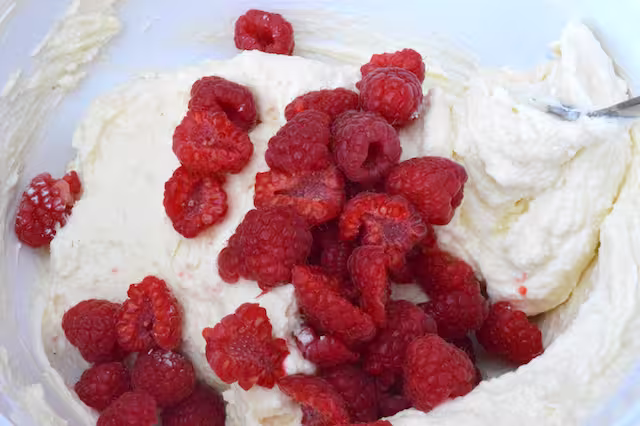 Raspberries added to cheesecake bowl.