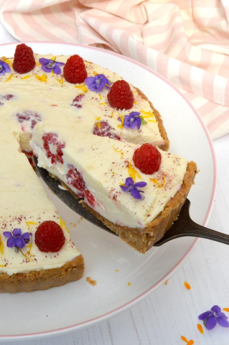 Slice of raspberry white chocolate cheesecake being served.