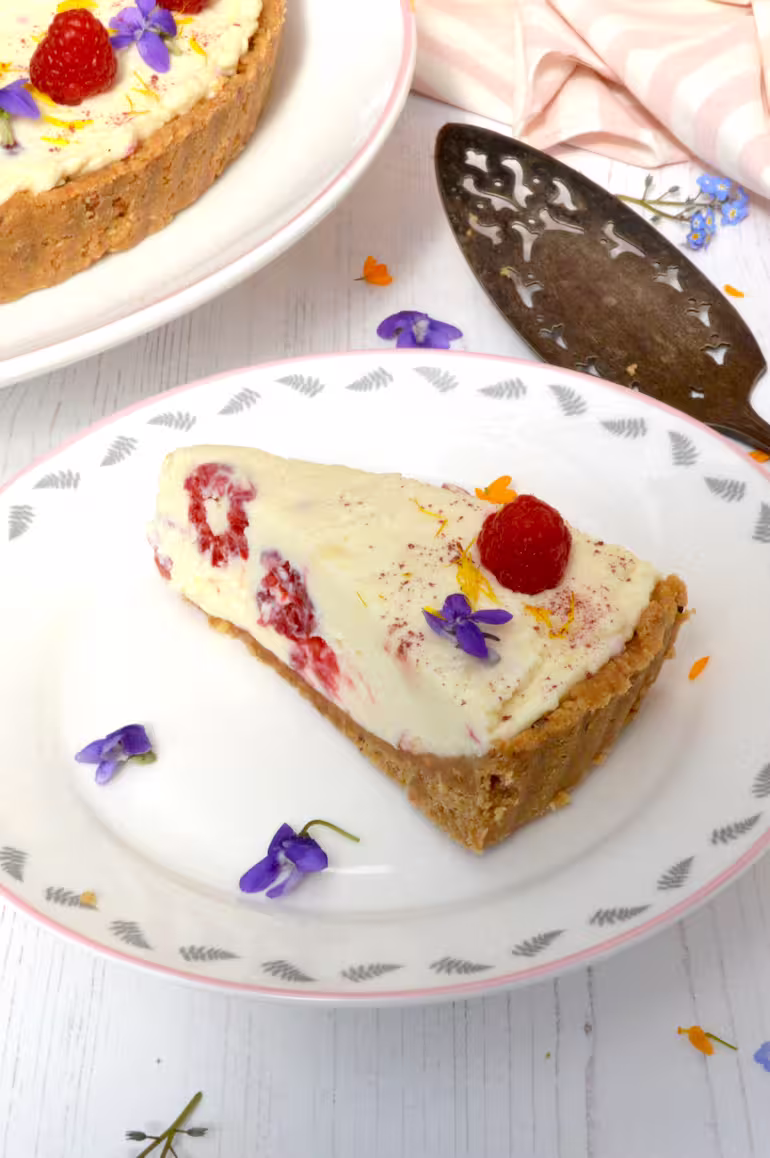 Slice of raspberry white chocolate cheesecake on plate.
