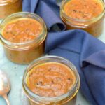 Jars of Indian-style rhubarb pickle with navy cloth.