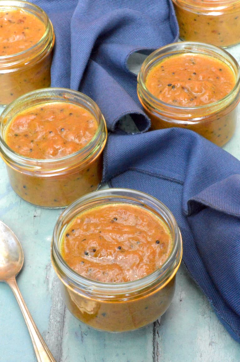 Jars of Indian-style rhubarb pickle with navy cloth.
