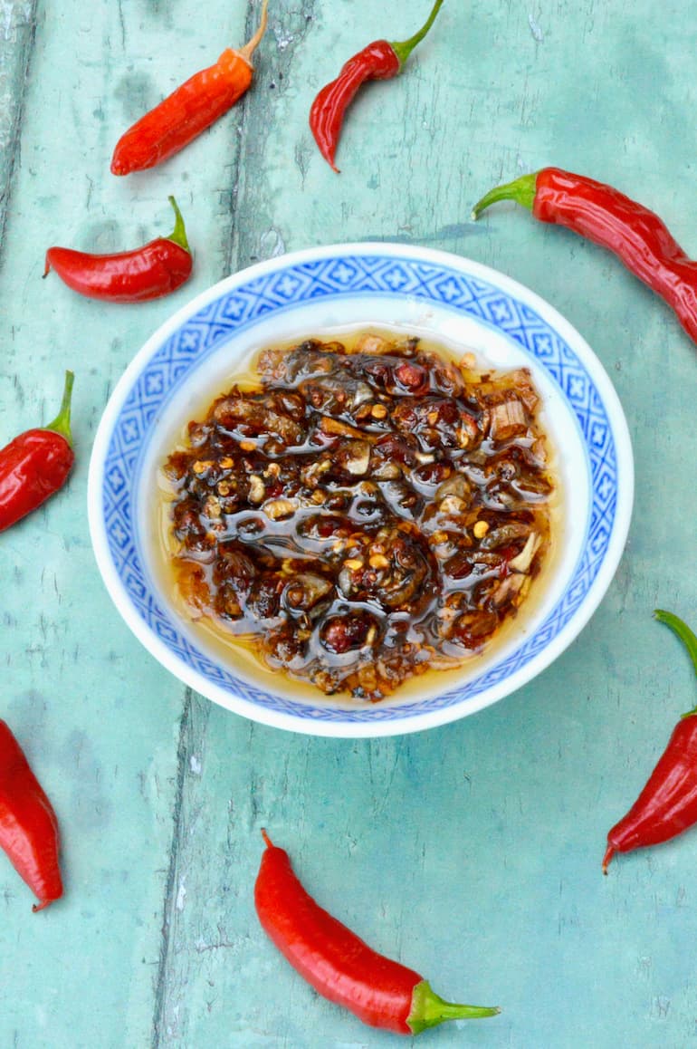 Dish of homemade crispy chilli oil with red chillies.