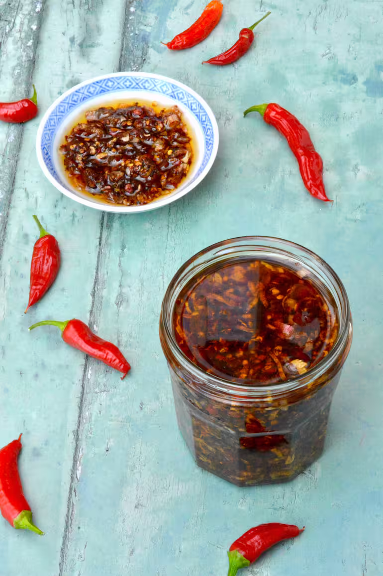 Jar of homemade crispy chilli oil and some in little dish.