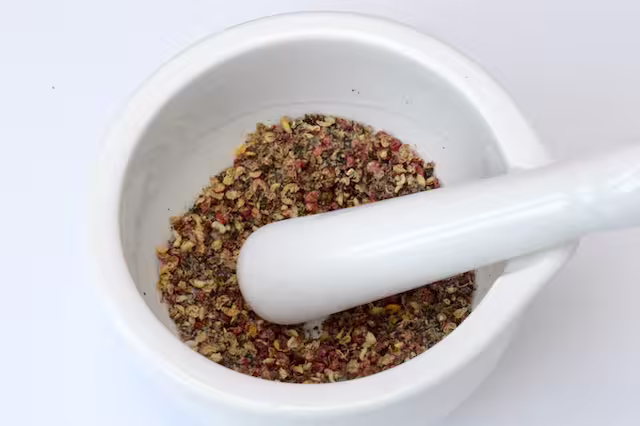 Crushed peppercorns in mortar with pestle.