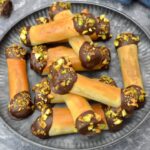 Homemade Dubai chocolate filo rolls stacked up on a platter.