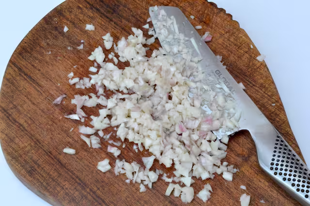 Lots of chopped garlic on board with knife.