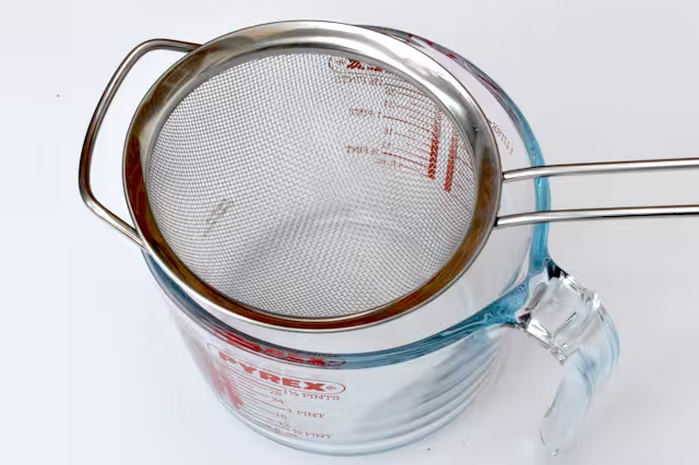 Sieve on top of pyrex jug.