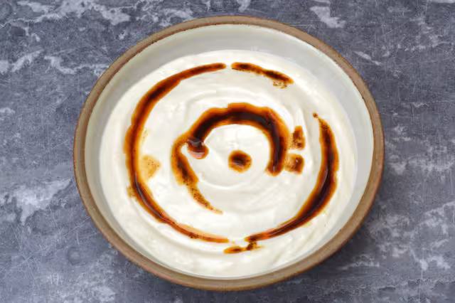 Spiced oil drizzled over tahini yoghurt sauce.