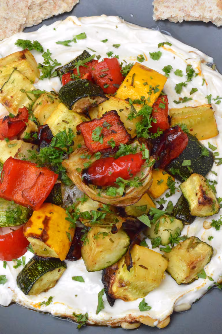 Roasted veg on a bed of tahini yoghurt sauce.