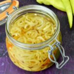 Open jar of pickled ohnivec chilli slices.