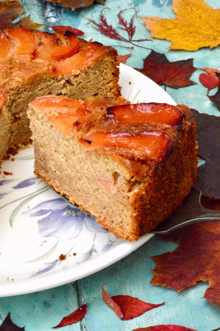 Slice of homemade quince cake with autumn leaves.