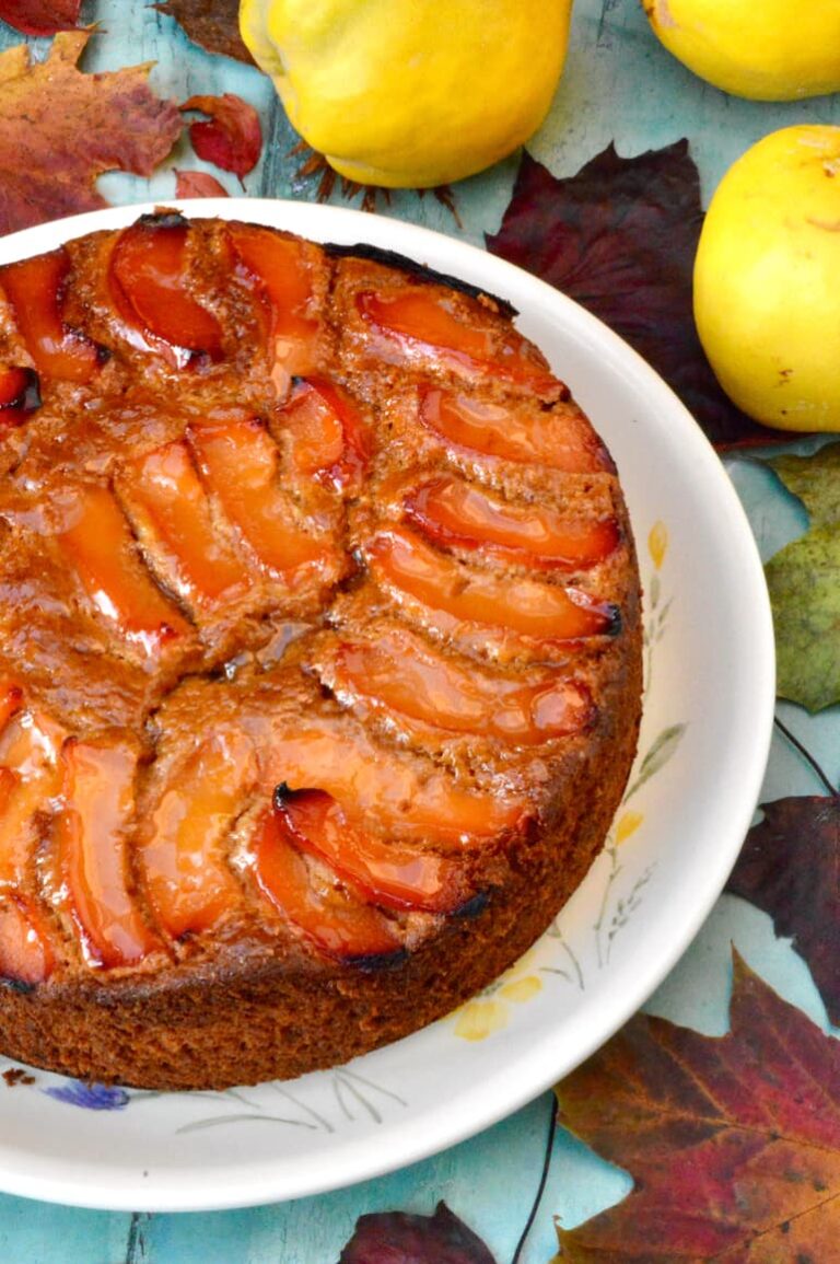 Quince cake decorated with syrupy slices. Autumn leaves and 3 quinces.
