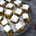 Homemade stollen bites on platter with pine cones on side.