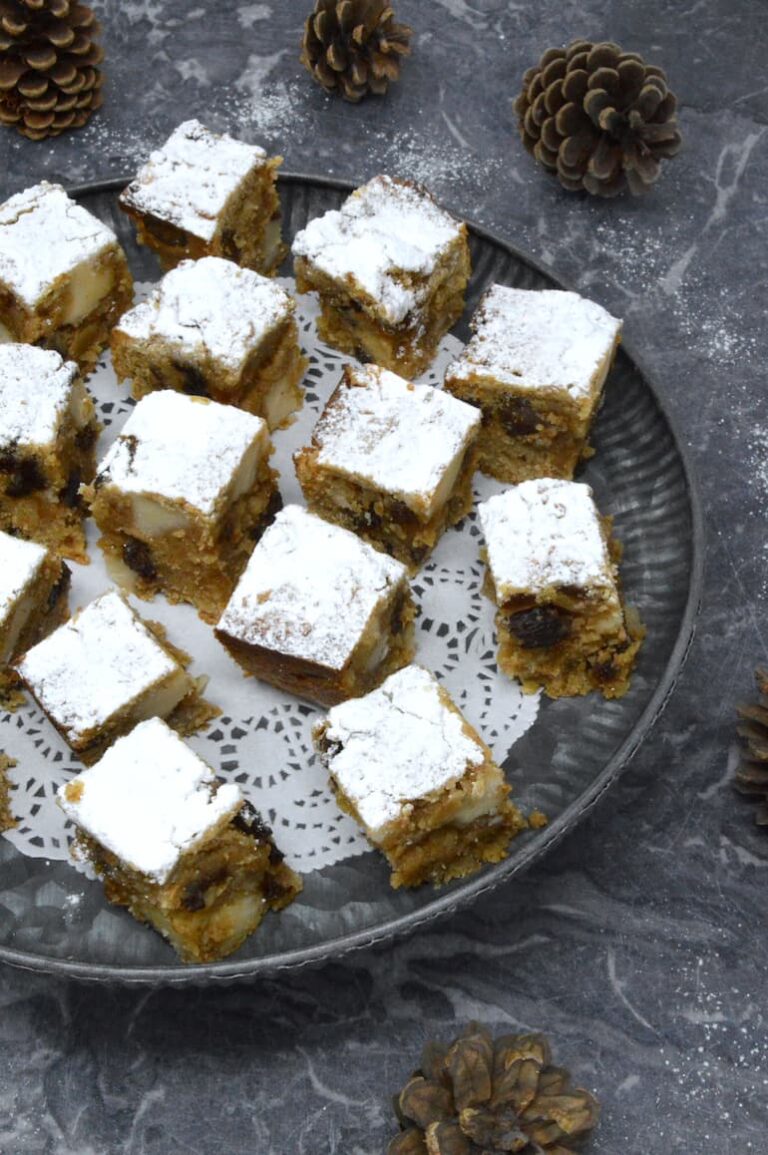 Homemade stollen bites on platter with pine cones on side.