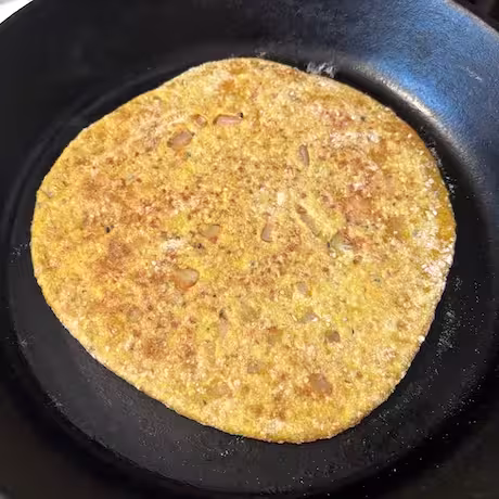 Paratha flipped over to show baked side.