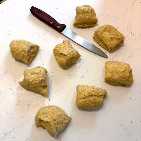 Dough cut into eight equal pieces with knife.