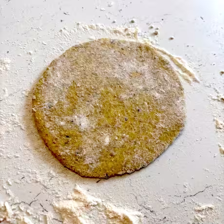 Dough rolled into small circle on floured surface.