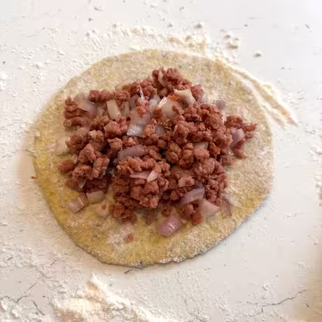 Keema stuffing on rolled out dough.
