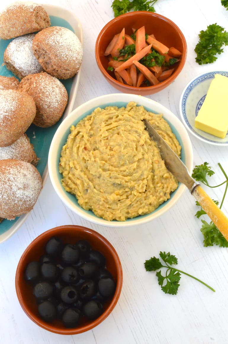 Vegan fish pâté as part of a homemade "Portuguese couvert" with olives, pickled carrots, bread and butter.