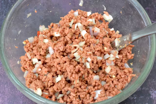 Vegan mince stuffing mixed in bowl with knife.