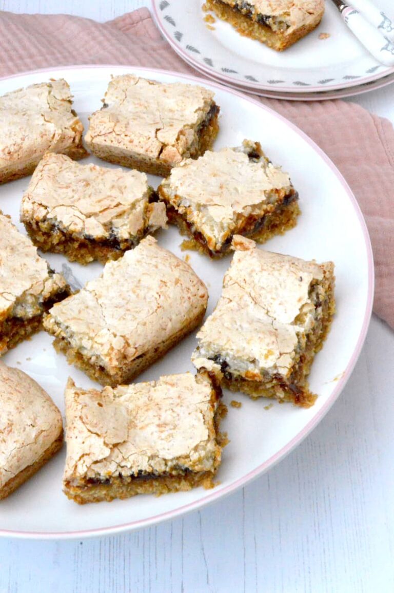 Homemade easy jam coconut slice pieces on cake stand.