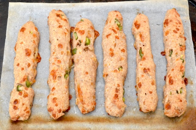 Cheese and chilli spelt breadsticks on baking tray.