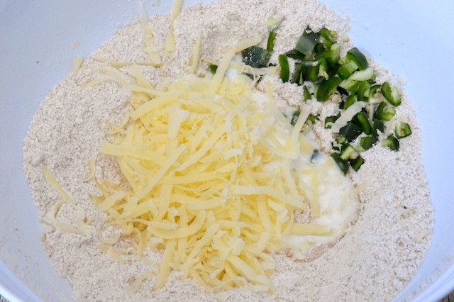 Grated cheese and chopped chilli in bowl with yoghurt and wholemeal spelt flour.