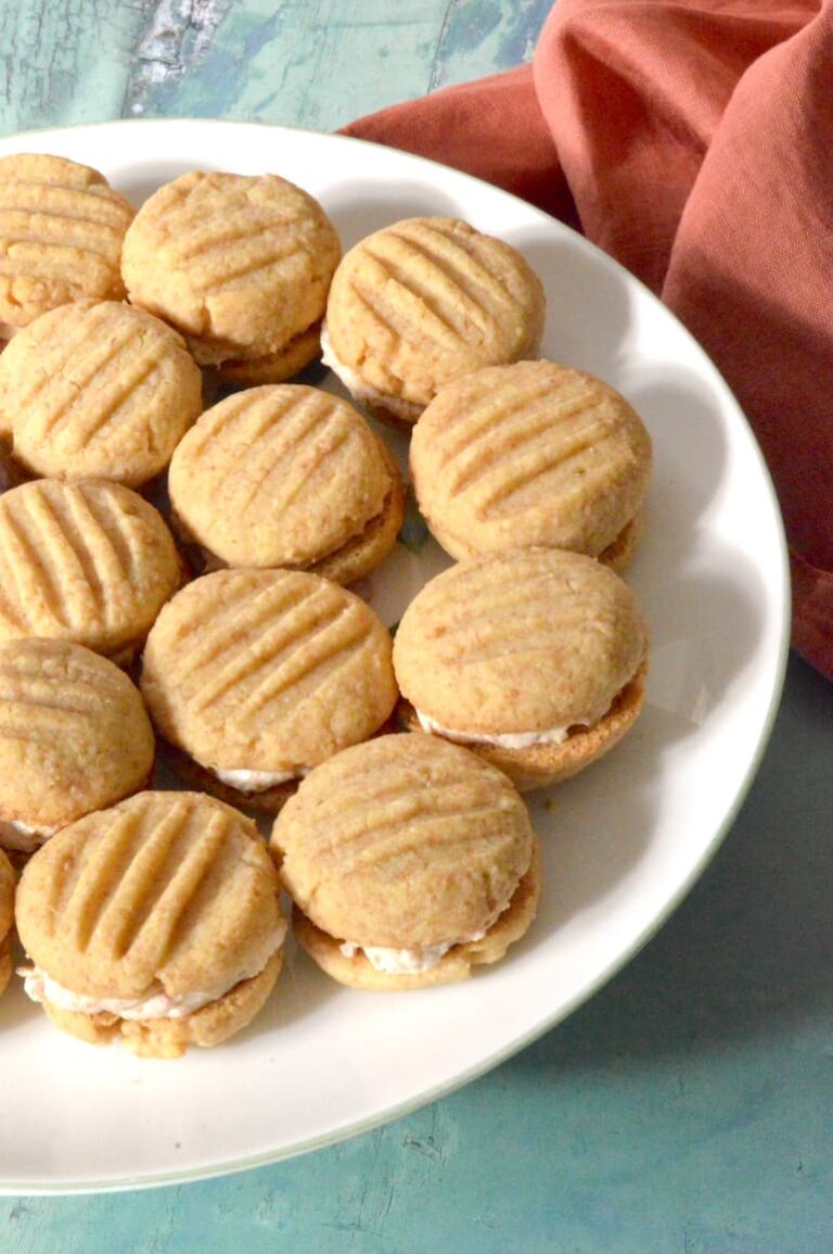 Rhubarb and custard biscuits sandwiched with cream filling on plate.