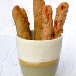 Easy no yeast spelt breadsticks in ceramic beaker.