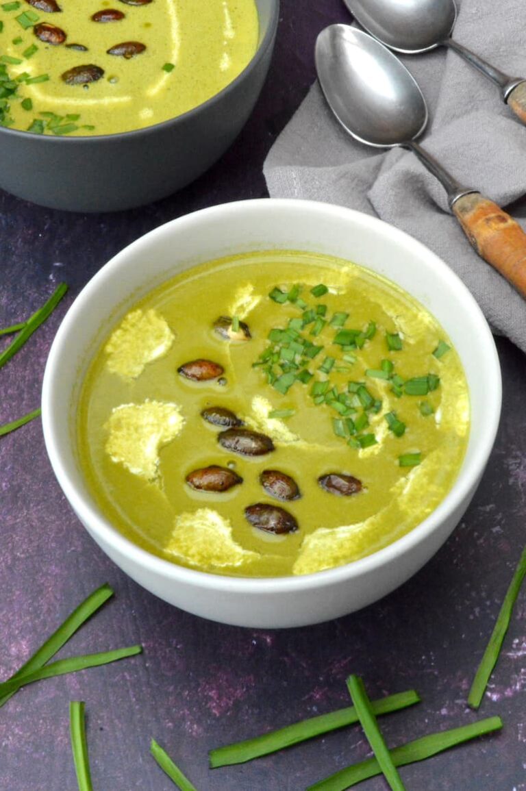 Whole bowl of three-cornered leek and potato soup topped with roasted pumpkin seeds.
