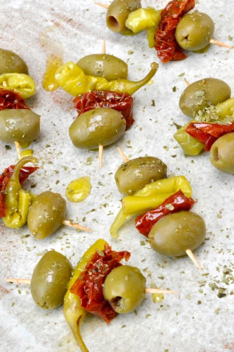 Homemade vegan gildas pintxo on a plate sprinkled with seaweed flakes.