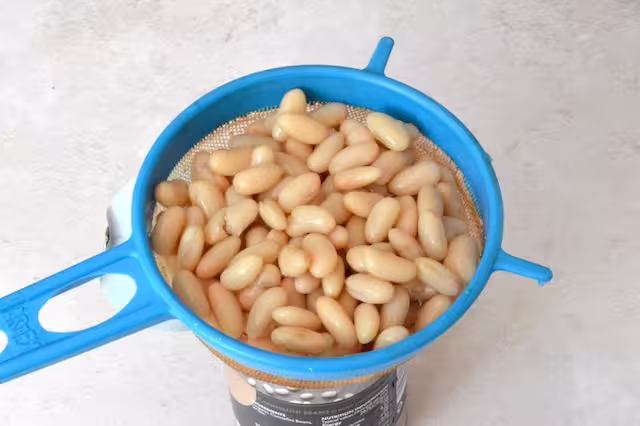 Cannellini beans draining in a sieve.