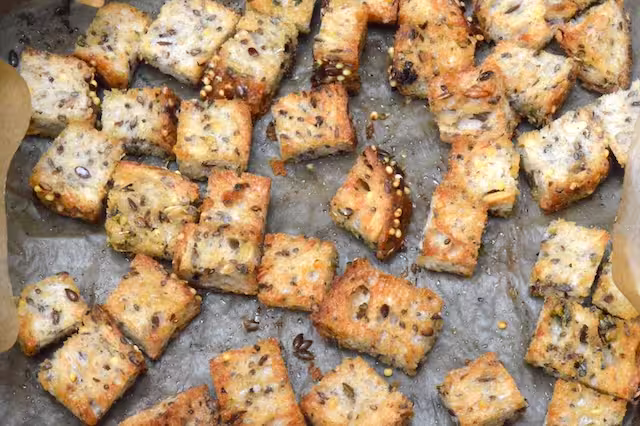 Croutons in lined air fryer basket.