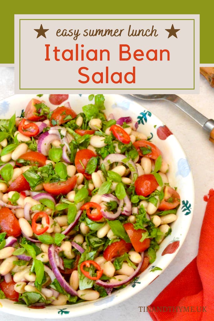 Bowl of Italian bean salad with servers and napkin on the side.