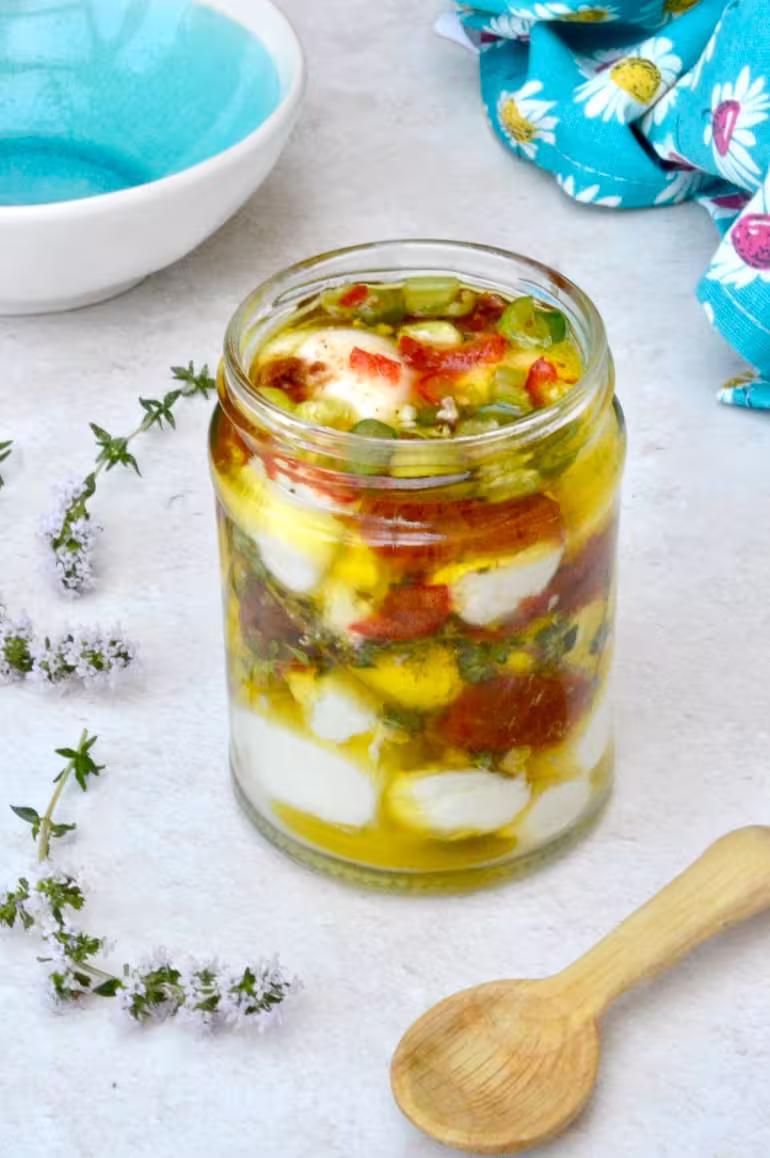 Jar of nodini cheese in olive oil marinade.