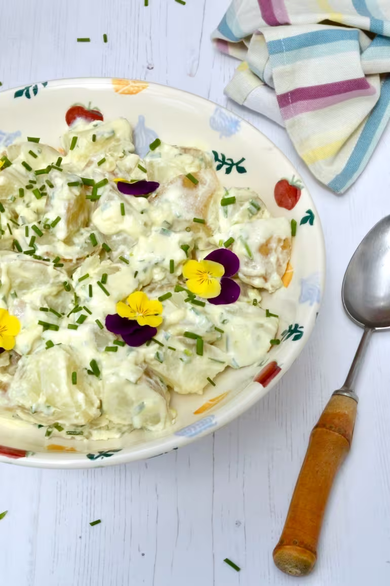 Simple potato salad with chives and spoon on side.