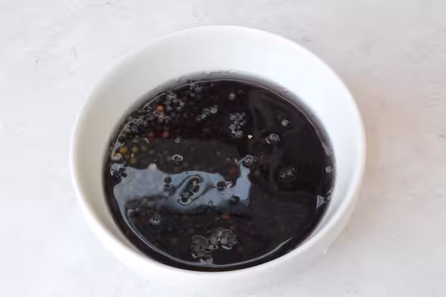 Bowl of black lentils soaking in water.