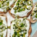 Platter of broad bean toast slices slathered with garlicky whipped cream cheese.