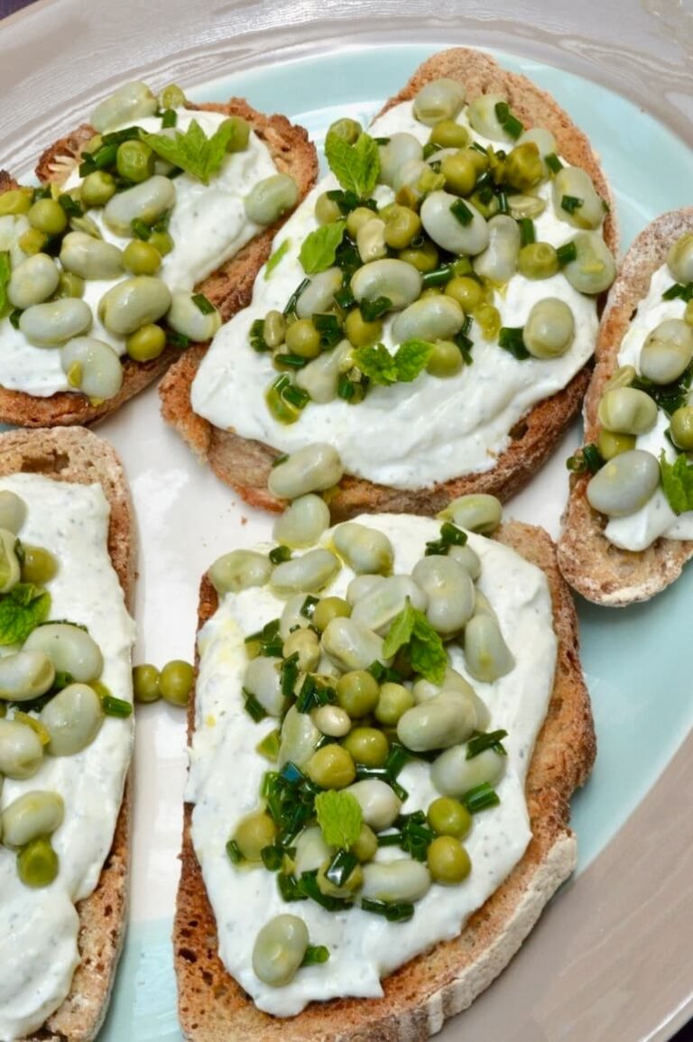 Platter of broad bean toast slices slathered with garlicky whipped cream cheese.