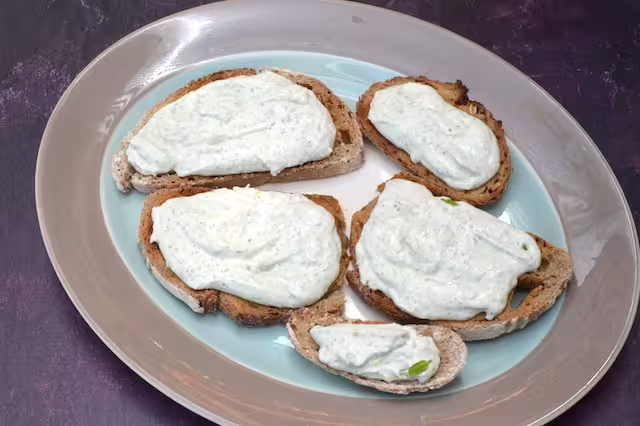 Minty, garlicky whipped cottage cheese spread over sourdough toast slices.